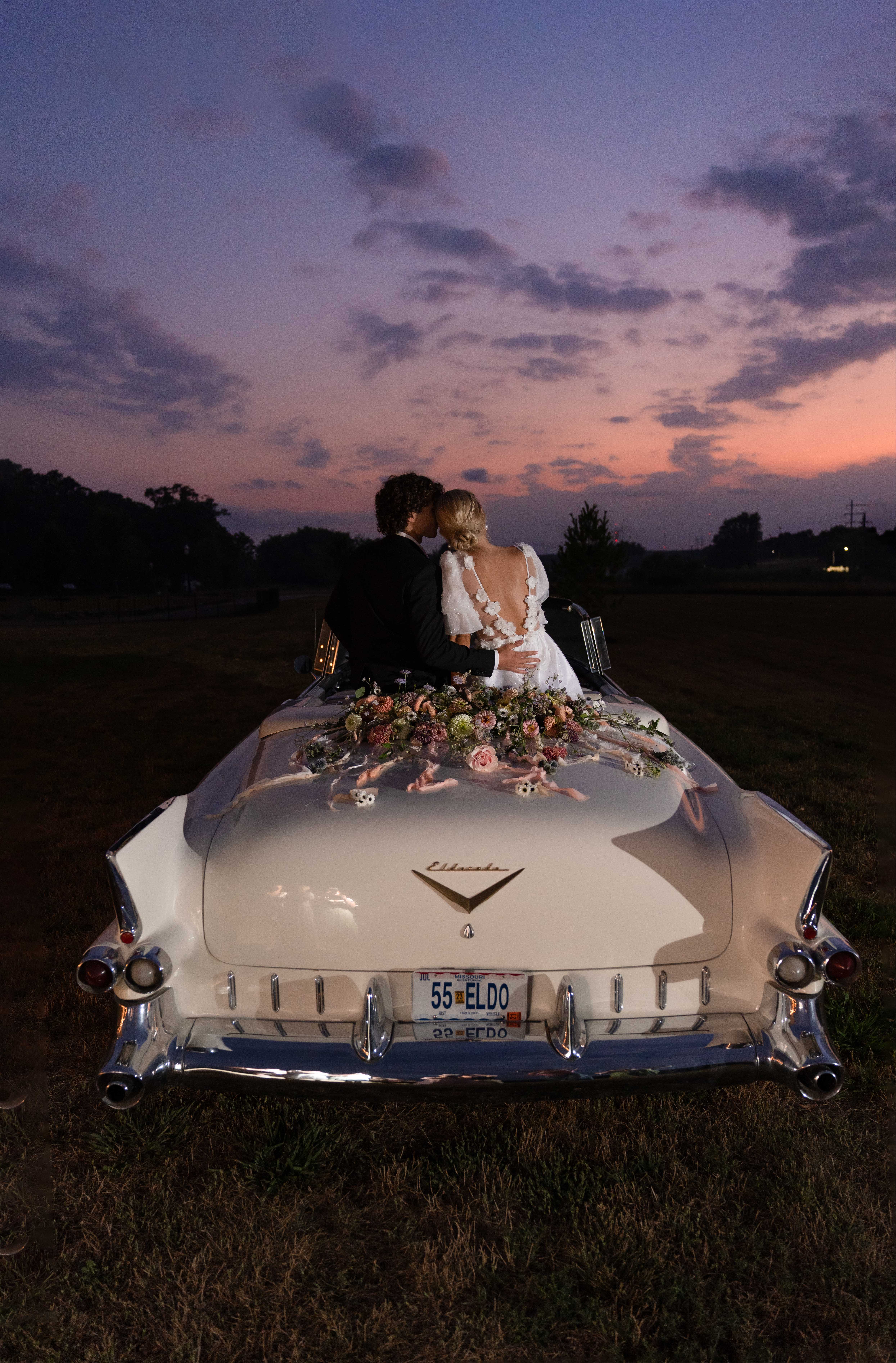wedding couple with classic car at sunset