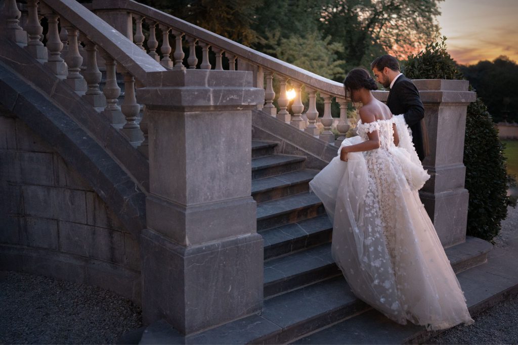 elegant staircase with bride and groom by lake of the Ozarks wedding photographer The Bennetts
