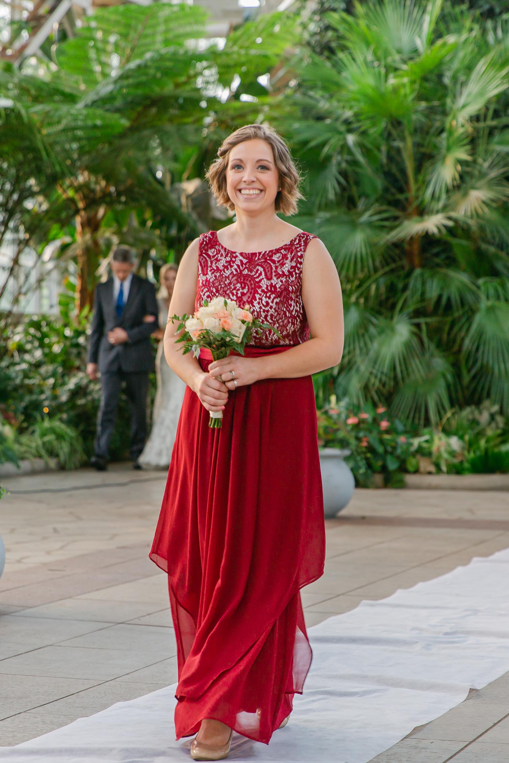 a woman in a red dress holding a bouquet of flowers